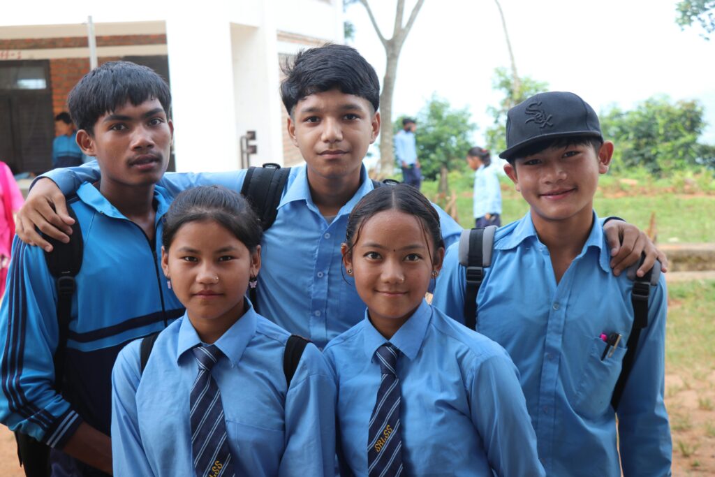 Five teenage students in school uniforms smiling together outdoors. Perfect for education and youth themes.